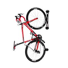 A black and red road bike stored in a classic road bike rack on a white background.
